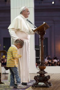 Pope Francis touches the head of a child as he leads a special audience with families at St. Peter Square in Vatican