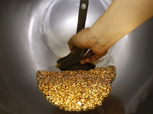 A worker uses a brush to gather gold shots at a jewellery factory in Chiba, east of Tokyo